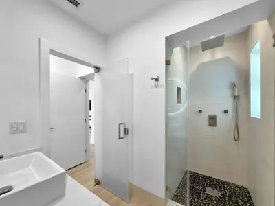 a white bathroom with a shower and a sink at Brickell, Remote-Ready Oasis in Miami