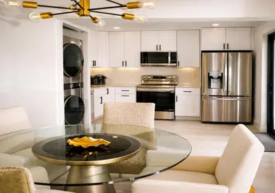 a kitchen with a glass table and white cabinets at Casa Hard Rock Stadium in Miami Gardens