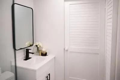 a white bathroom with a sink and a mirror at Casa Hard Rock Stadium in Miami Gardens