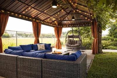 a patio with blue couches and a pergola at Casa Hard Rock Stadium in Miami Gardens