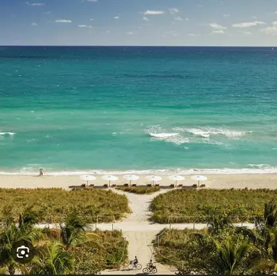 an aerial view of a beach with umbrellas and the ocean at A place that will make you want to come back again in Miami Beach