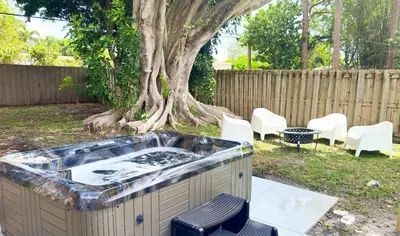 a hot tub in a yard next to a tree at The Chill Pill - Wilton Drive and Jacuzzi in Fort Lauderdale