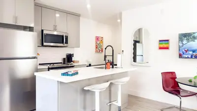 a white kitchen with a sink and a refrigerator at The Chill Pill - Wilton Drive and Jacuzzi in Fort Lauderdale