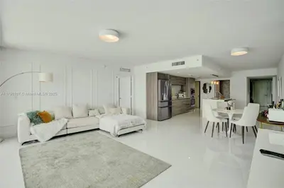 a white living room with a couch and a table at Beachfront Bliss in Miami in Miami Beach