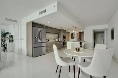 a kitchen with a white table and white chairs at Beachfront Bliss in Miami in Miami Beach