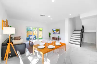 a living room with a dining room table and a staircase at Family-Friendly Townhouse w Private Parking Included in Miami