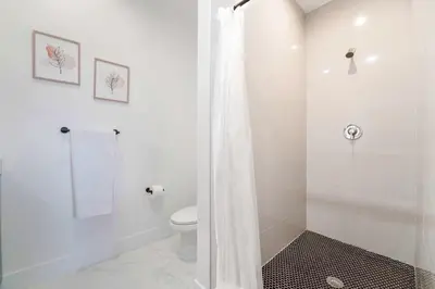 a white bathroom with a toilet and a shower at Family-Friendly Townhouse w Private Parking Included in Miami