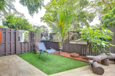 a backyard with a chair and a fence at 3 Mi to Beach Hollywood Treehouse with Deck and Yard! in Hollywood