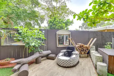 a backyard with a wooden deck with a fence at 3 Mi to Beach Hollywood Treehouse with Deck and Yard! in Hollywood