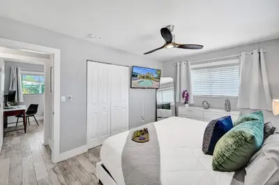 a bedroom with a white bed and a ceiling fan at NEW! Private Oasis with Heated Pool Minutes to Wilton Dr and the Beach in Fort Lauderdale