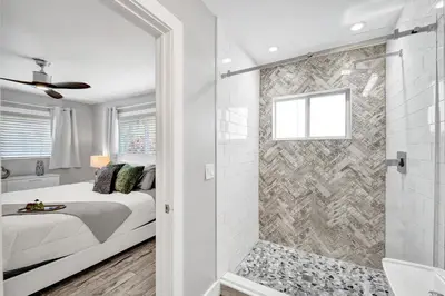 a bedroom with a shower and a bed and a bathroom at NEW! Private Oasis with Heated Pool Minutes to Wilton Dr and the Beach in Fort Lauderdale