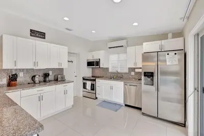 a kitchen with white cabinets and stainless steel appliances at Waterfront Oasis with Private Pool in Fort Lauderdale
