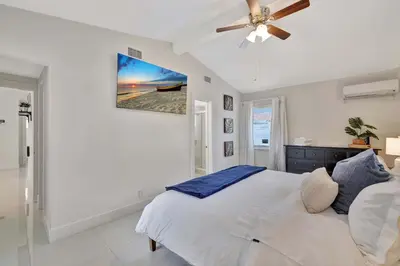 a white bedroom with a bed and a ceiling fan at Waterfront Oasis with Private Pool in Fort Lauderdale