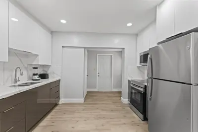 a white kitchen with a refrigerator and a sink at Family Oasis Near Hard Rock Stadium & Beaches in Norland