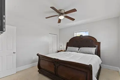 a bedroom with a bed with a ceiling fan at Family Oasis Near Hard Rock Stadium & Beaches in Norland
