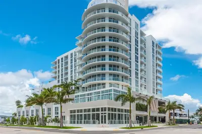 a tall white building with palm trees in front of it at Tiffany Shoreline - PH Floor, Ocean View, Walk to beach in Fort Lauderdale