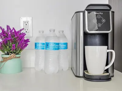 a group of bottles of water next to a coffee maker at X Lounge VI-Premium Corner Residence in Miami