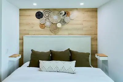 a bedroom with a white bed with a wooden wall at Skyline Studio at Roney Palace - 1429 in Miami Beach