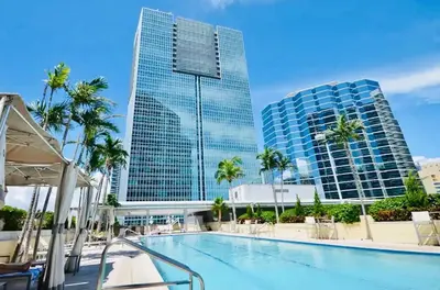 a swimming pool with palm trees and buildings at ★Luxury Studio with king bed+Free Parking+Netflix★ in Miami