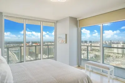 a bedroom with a bed and large windows at A Breathtaking Oceanview - High Rise Luxury Condo in Sunny Isles Beach