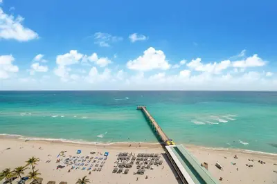 a view of a beach with chairs and the ocean at Balcony on the Ocean - Picture Perfect in Sunny Isles Beach