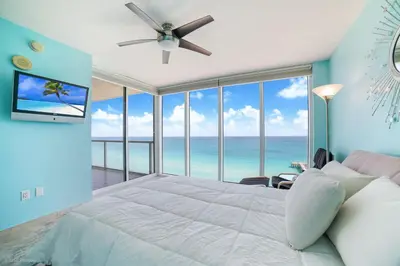 a bedroom with a large bed with a ceiling fan at Balcony on the Ocean - Picture Perfect in Sunny Isles Beach