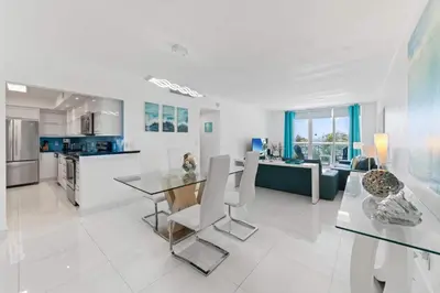 a kitchen and living room with a table and chairs at Ocean Wind - Luxury Beachfront Condo with Pool & Gym in Hollywood