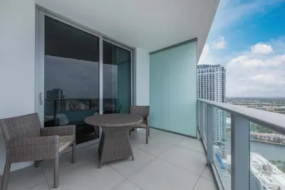 a balcony with chairs and a table on a building at Luxury Living on the Beach with Resort Amenities in Hollywood