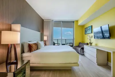 a bedroom with a bed and a desk with a television at Luxury Living on the Beach with Resort Amenities in Hollywood