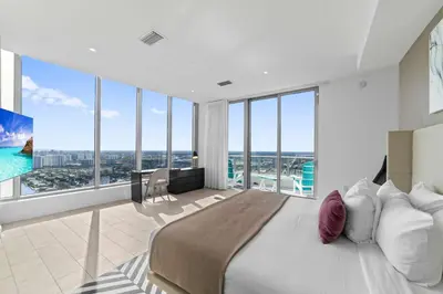 a bedroom with a large bed and large windows at 2BR Ocean Penthouse - Private Terrace & Hot Tub in Hollywood