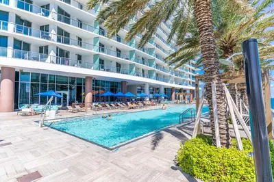 a swimming pool with a palm tree and a hotel at Luxury Penthouse 4 BDR with Resort Amenities in Hollywood