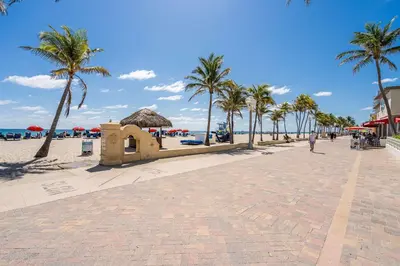 a beach with palm trees and a brick road at Condo with 1 Bedroom Terrace and Hot Tub in Hollywood