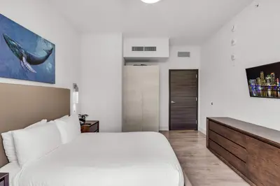 a white bedroom with a large bed and a door at Condo with 1 Bedroom Terrace and Hot Tub in Hollywood