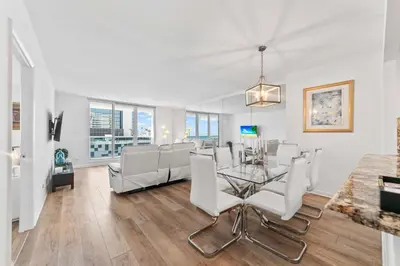 a dining room with a glass table and white chairs at Oasis on the Beach - For 4 in Miami Beach