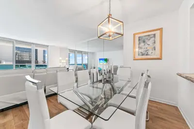 a dining room with a glass table and white chairs at Oasis on the Beach - For 4 in Miami Beach