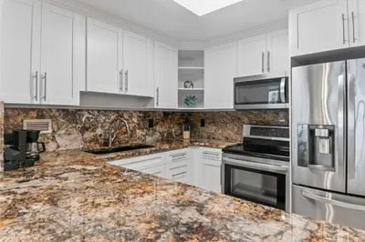a kitchen with white cabinets and a marble counter top at Oasis on the Beach - For 4 in Miami Beach