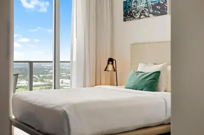 a bedroom with a large bed and a large window at 5-BR Retreat Resort & Valet Included 14 Guests in Hollywood