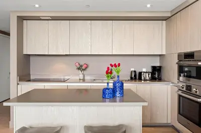 a kitchen with white cabinets and blue vases with flowers at 5-BR Retreat Resort & Valet Included 14 Guests in Hollywood