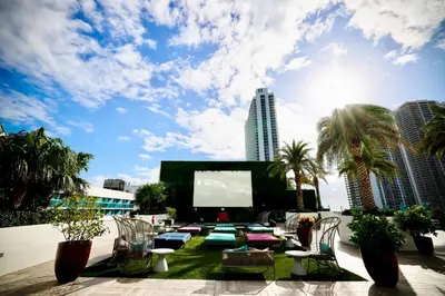 a large outdoor patio with chairs and a screen at 5-BR Retreat Resort & Valet Included 14 Guests in Hollywood