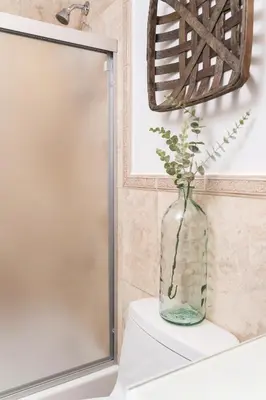 a vase with flowers sitting on top of a bathroom sink at Instant Stay Ocean Drive in Miami Beach