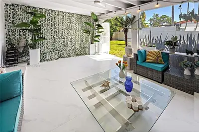 a patio with a couch and a glass table at Bayside Bliss on Marseille in Miami Beach