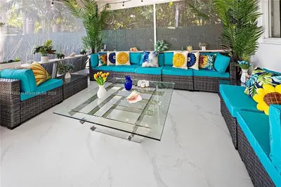 a living room with blue couches and a glass table at Bayside Bliss on Marseille in Miami Beach