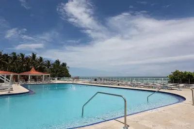 a swimming pool with a view of the ocean at Beachfront Studio - Marco Polo Sunny Isles -2Beds in Sunny Isles Beach