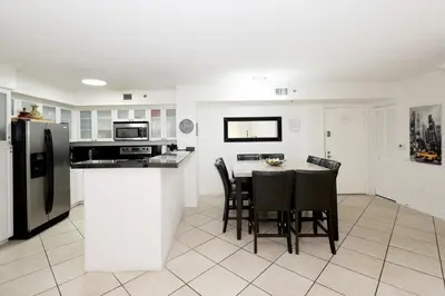 a kitchen with a table and chairs and a refrigerator at Apartment 2 Bedrooms at Yacht Club of Aventura in Miami