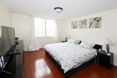 a white bedroom with a bed and a television at Apartment 2 Bedrooms at Yacht Club of Aventura in Miami