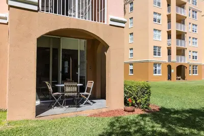a patio with a table and chairs in front of a building at Luxe 3BR Apartment with Great Patio at Yacht Club in Aventura