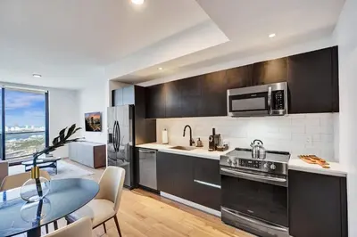 a kitchen with stainless steel appliances and a dining table at Miami Lux 1BR 37th Floor Bay City Views in Miami