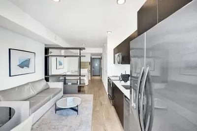 a living room with a couch and a kitchen at 4704 Lux Miami Studio City Bay Views in Miami
