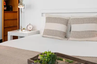 a white bed with pillows and a clock on a table at Oceanview Private Penthouse at The Setai - 3803 in Miami Beach