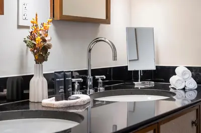 a bathroom with two sinks and a vase with flowers at Oceanview Private Penthouse at The Setai - 3803 in Miami Beach